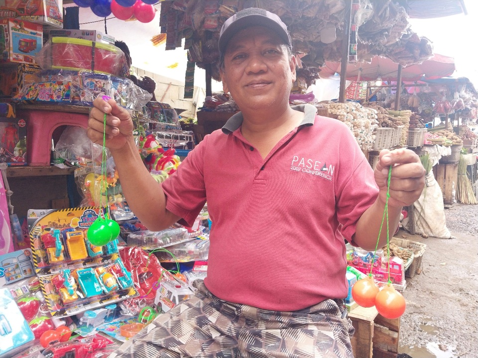 Toy seller Jemaras poses for the Jakarta Globe with the popular latto-latto on both hands, in Kebayoran Lama, Jakarta on Jan. 5, 2023. (JG Photo/Jayanty Nada Shofa)