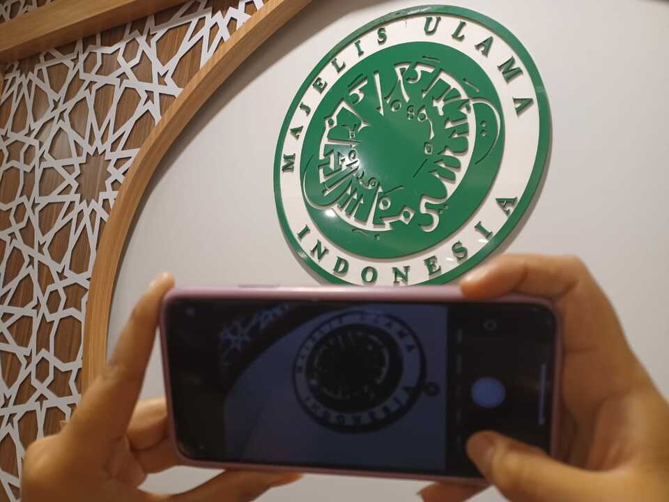 A man takes the picture of the Indonesian Ulema Council (MUI) logo in Jakarta. (Photo courtesy of MUI)