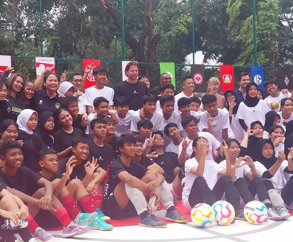 Former Borussia Dortmund’s goalkeeper Roman Weidenfeller takes a picture with young Indonesian footballers at the refurbished football pitch at RPTRA Bhinneka in Jakarta on Feb. 11, 2023. The pitch revamp is part of the Bundesliga's pitch refurbishing project Common Ground. (JG Photo/Jayanty Nada Shofa)