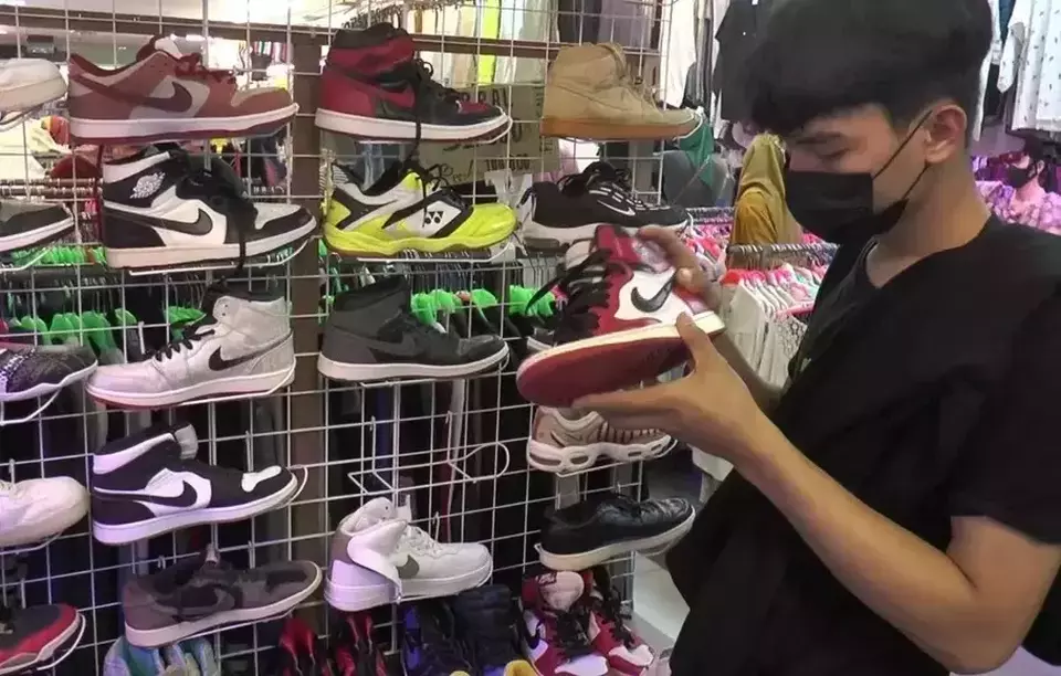 A teenage boy inspects a used Nike sneaker at Senen Market, Jakarta, on March 12, 2023. (Beritasatu Photo/Cindy Layan)