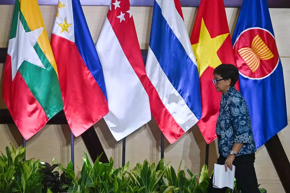 Foreign Affairs Minister Retno Marsudi passes by the flags of ASEAN and the bloc's member states at the ASEAN Foreign Ministers' Retreat press conference in Jakarta on Feb. 4, 2023. (Antara Photo/Aditya Pradana Putra)	