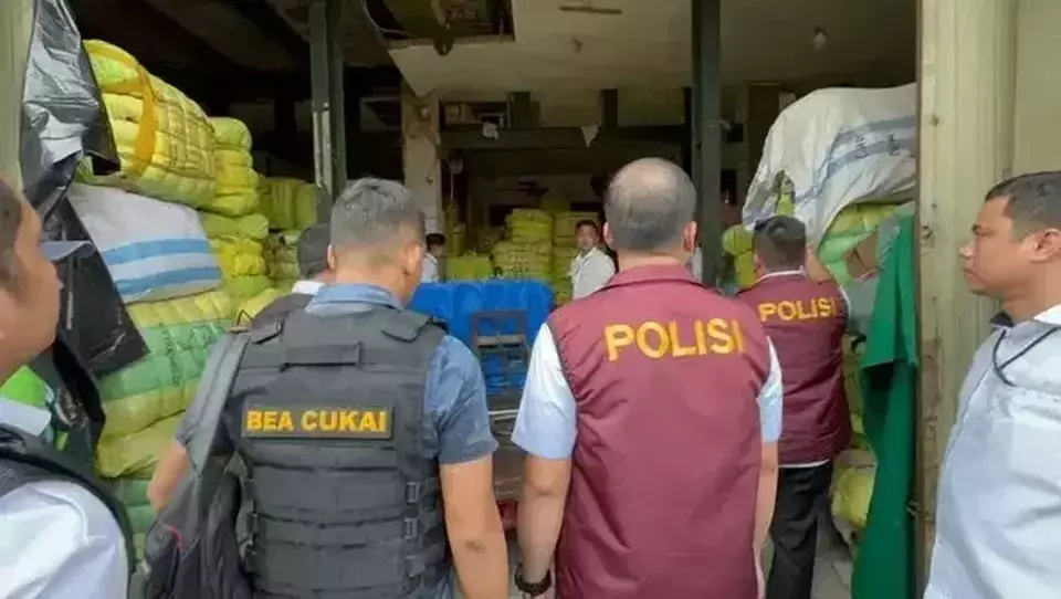Police and customs officials conduct a raid at a used cloth warehouse in Jakarta on March 20, 2023. (Photo courtesy of the National Police)