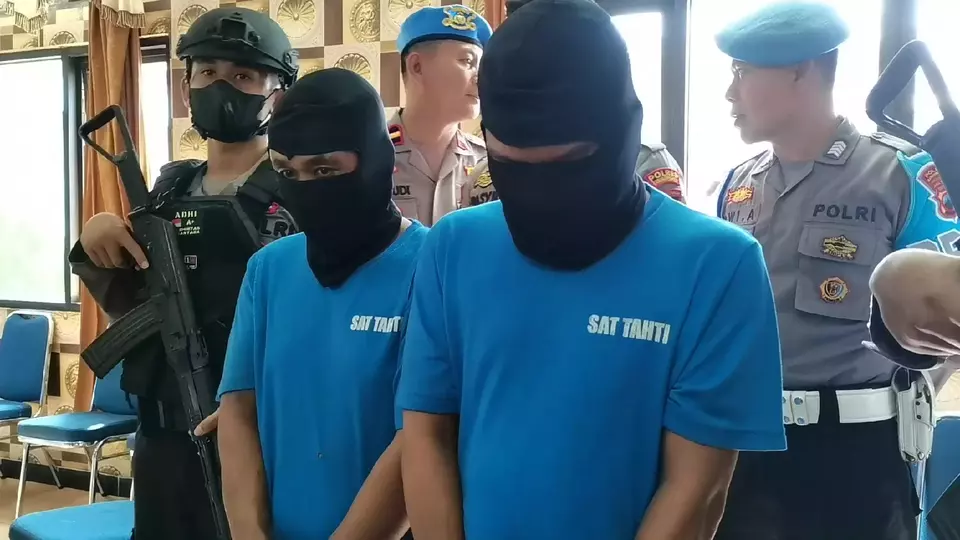 Serial murder suspect Tohari aka Mbah Slamet, right, and suspected accomplice identified as BS whose faces are covered with balaclavas are presented during a press conference at Banjarnegara Police headquarters in Central Java on April 3, 2023. (B-Universe Photo/Pujud Andriastanto)