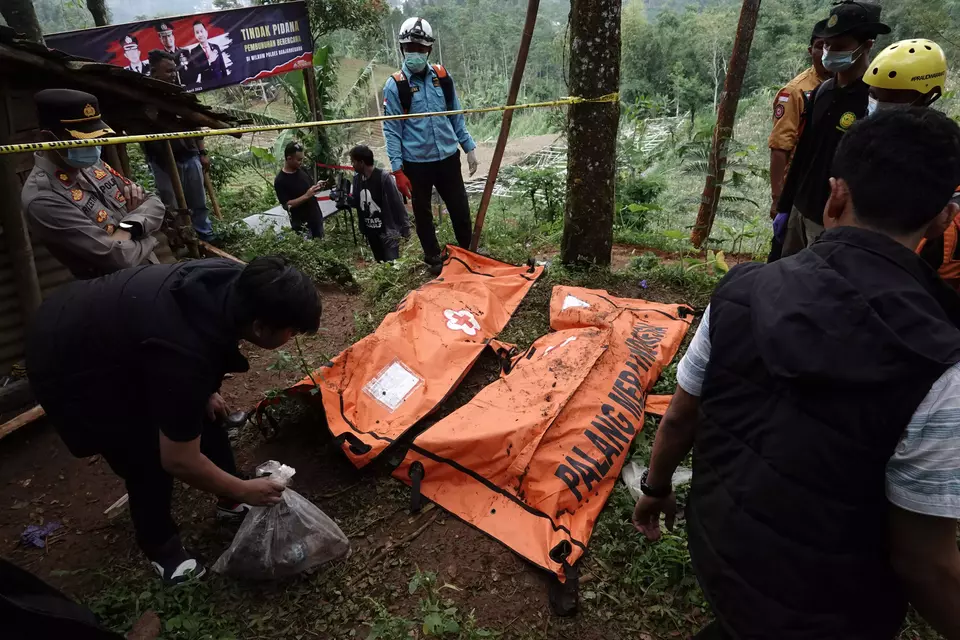 Police and rescue workers retrieve two bodies in the village of Balun, Banjarnegara, in Central Java province, on April 4, 2023, as part of the ongoing investigation into serial murder suspect Slamet Tohari who is accused of killing at least 12 people. (Antara Photo/Idhad Zakaria)