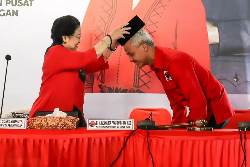Central Java Governor Ganjar Pranowo, right, is worn a traditional cap peci by Indonesian Democratic Party of Struggle (PDI-P) Chairwoman Megawati Soekarnoputri after he is named a presidential candidate at Batu Tulis Palace in Bogor on April 21, 2023. (Antara Photo)