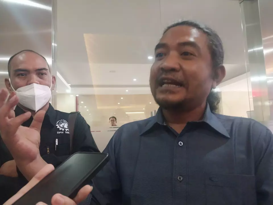Indonesian Migrant Worker Union (SBMI) chairman Hariyanto Suwarno speaks to reporters at the police