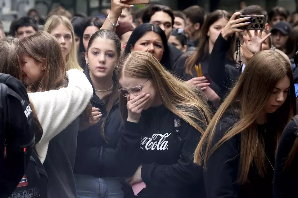 School children mourn the victims near the Vladislav Ribnikar school in Belgrade, Serbia, Thursday, May 4, 2023. Many wearing black and carrying flowers, scores of Serbian students on Thursday paid silent homage to their peers killed a day earlier when a 13-year-old boy used his father