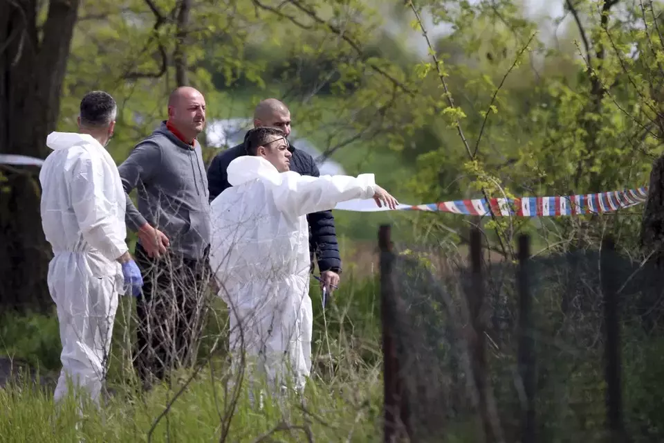 Forensic police inspect the scene around a car in the village of Dubona, some 50 kilometers (30 miles) south of Belgrade, Serbia, Friday, May 5, 2023. A shooter killed multiple people and wounded more in a drive-by attack late Thursday in Serbia's second such mass killing in two days, state television reported. (AP Photo/Armin Durgut)