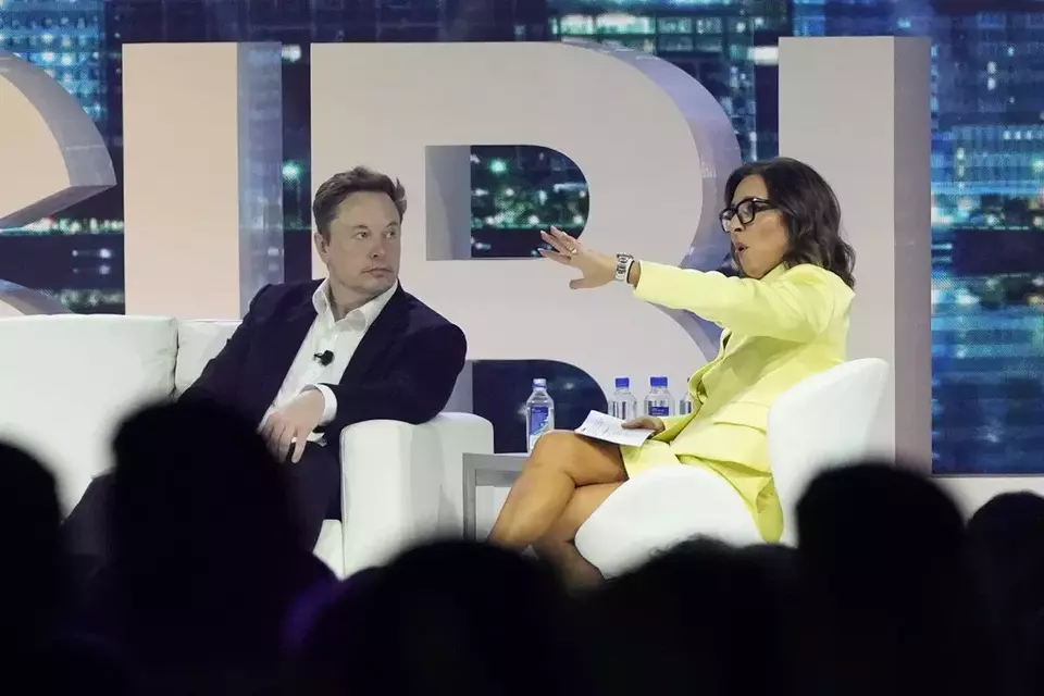FILE - Twitter CEO Elon Musk, center, speaks with Linda Yaccarino, chairman of global advertising and partnerships for NBC, at the POSSIBLE marketing conference, Tuesday, April 18, 2023, in Miami Beach, Florida. (AP Photo/Rebecca Blackwell, File)