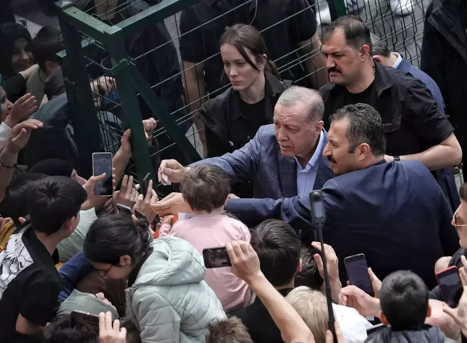Turkish President Recep Tayyip Erdogan with supporters at a polling station, in Istanbul, Turkey, Sunday, May 14, 2023. (DHA via AP)