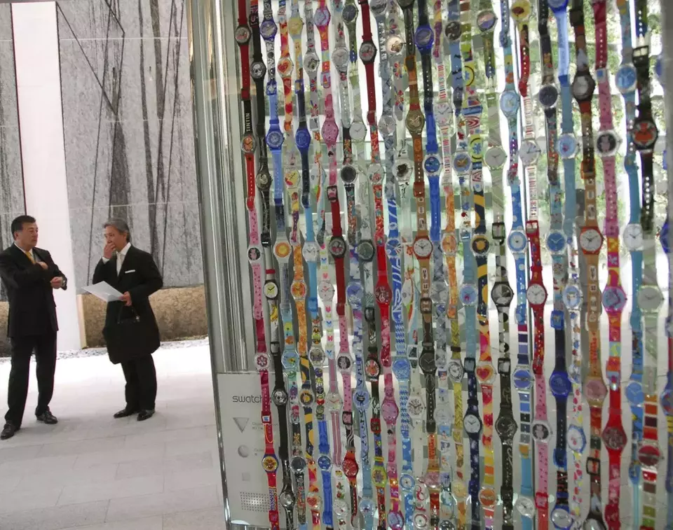 FILE - Swatch watches are displayed on the wall of an elevator at a Swatch Group