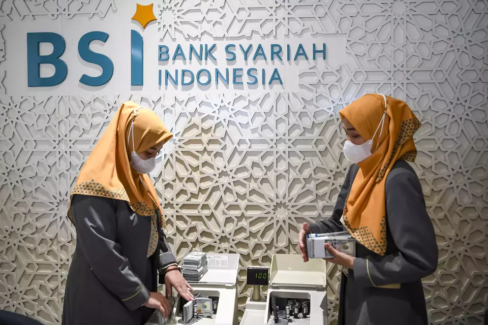 BSI tellers count money at one of its Jakarta branch offices on May 11, 2023. (Antara Photo/M Risyal Hidayat)