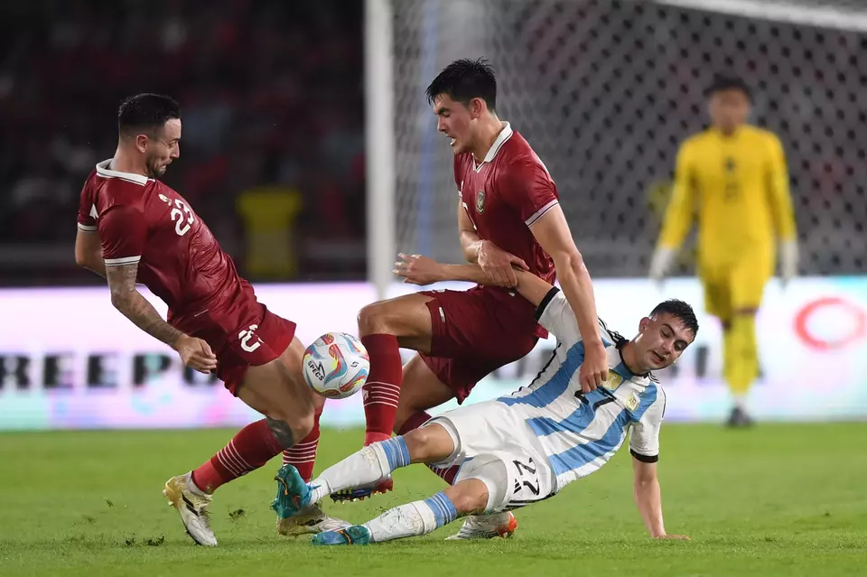 Indonesian defenders Marc Klok, left, and Elkan Baggott, center, fight for the ball with Argentina s Facundo Valentin Buonanotte, right, during a friendly at Bung Karno Stadium in Jakarta, Monday, June 19, 2023. (Antara Photo/Akbar Nugroho Gumay)