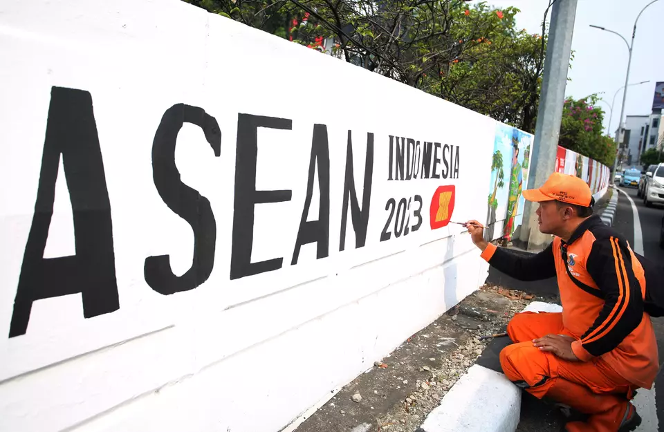 A public facility maintenance worker paints an ASEAN mural in Jakarta on July 26, 2023. (Antara Photo/Muhammad Iqbal)