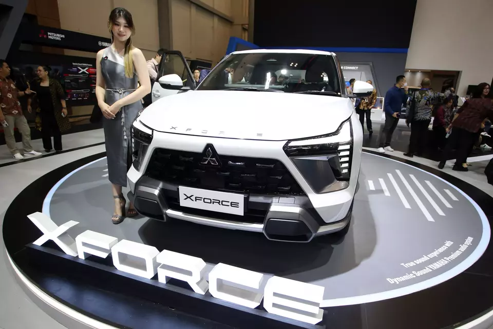 A model stands next to a Mitsubishi Xforce during the opening day of the GAIKINDO Indonesia International Auto Show (GIIAS) in Tangerang, Banten, Thursday, Aug. 10, 2023. (Antara photo)
