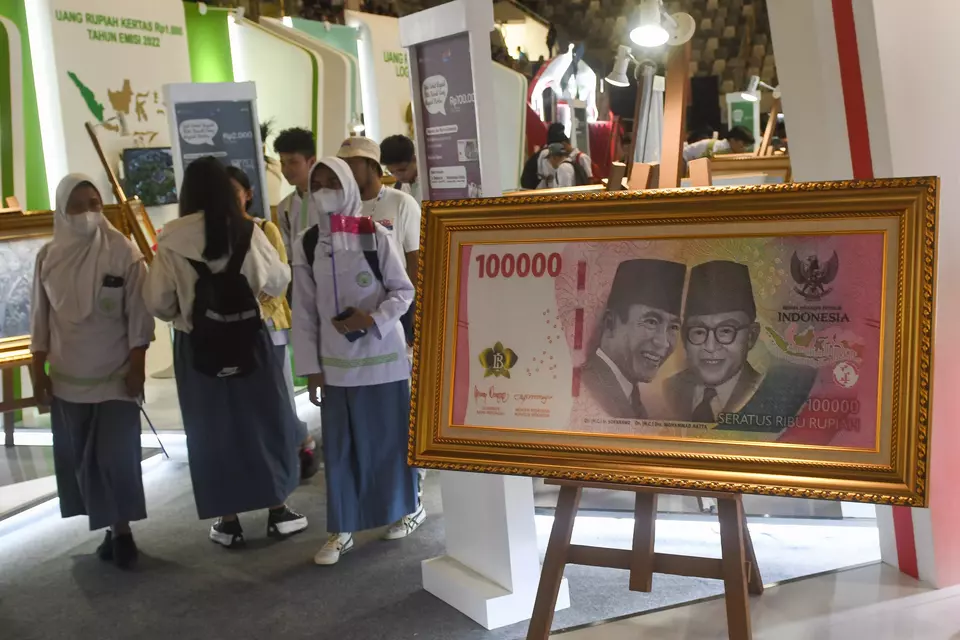 Students walk near an enlarged model of the Rp 100,000 banknote at the Sovereign Rupiah Festival at Istora Stadium in Jakarta, Friday, Aug. 18, 2023. (Antara photo/Aditya Pradana Putra)