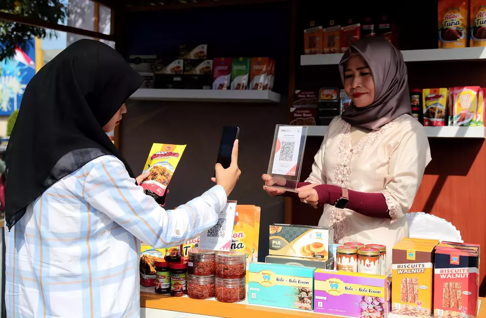A woman pays using the QRIS payment system at a festival in Ternate on August 18, 2023. (Antara Photo/Andri Saputra)