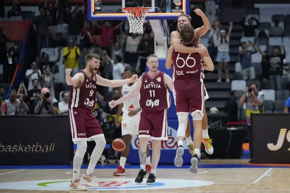 Latvia players celebrate after defeating France in their Basketball World Cup group H match at the Indonesia Arena stadium in Jakarta, Indonesia, Sunday, Aug. 27, 2023. (AP Photo/Achmad Ibrahim)