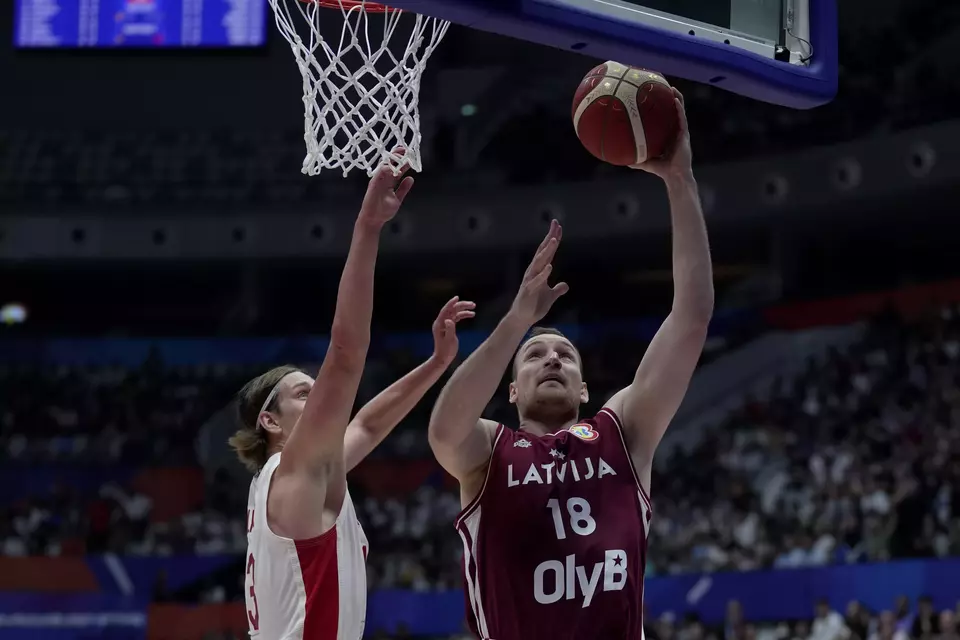 Latvia center Klavs Cavars (18) shoots against Canada forward Kelly Olynyk (13) during the Basketball World Cup group H match between Canada and Latvia at the Indonesia Arena stadium in Jakarta, Indonesia, Tuesday, Aug. 29, 2023. (AP Photo/Dita Alangkara)