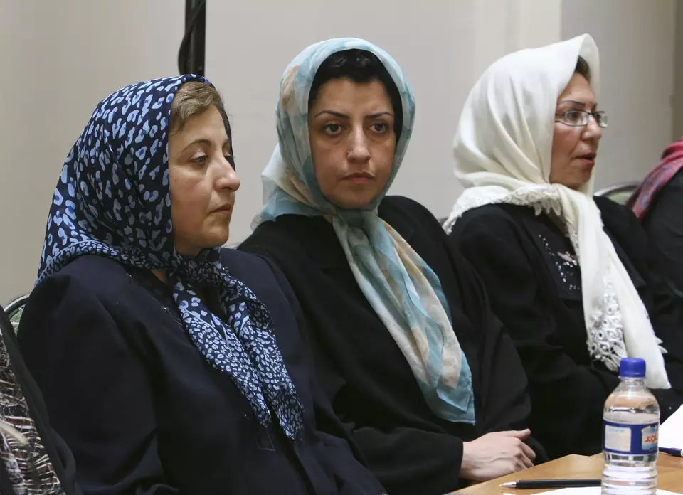 FILE - Prominent Iranian human rights activist Narges Mohammadi, center, sits next to Iranian Nobel Peace Prize laureate Shirin Ebadi, left, while attending a meeting on women