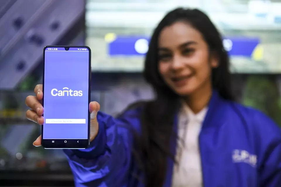 A woman shows the multi-lane free flow (MLFF) payment app Cantas at the Hunindotech 4.0 Business Forum in Jakarta on Nov. 14, 2023. (Antara Photo/Hafidz Mubarak A)