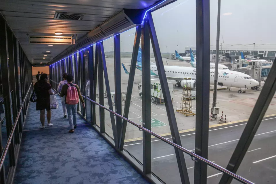 Passengers walk on a jet bridge at the Soekarno-Hatta international airport in Tangerang on Nov. 23, 2023. (Antara Photo/Yulius Satria Wijaya)