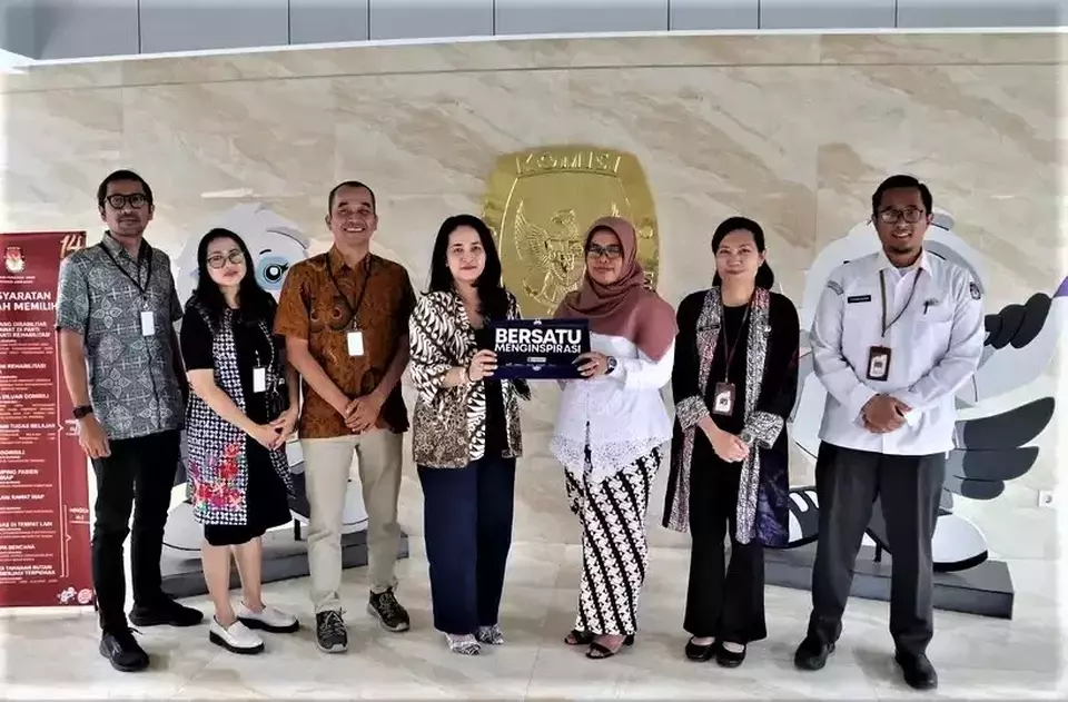 B-Universe Media Holdings Managing Director Apreyvita Wulansari, fourth left, hands a placard to West Java General Election Commission Chairwoman Ummi Wahyuni, fourth right, in Bandung, West Java, Thursday, Nov. 30, 2023. (Aep Supandi)