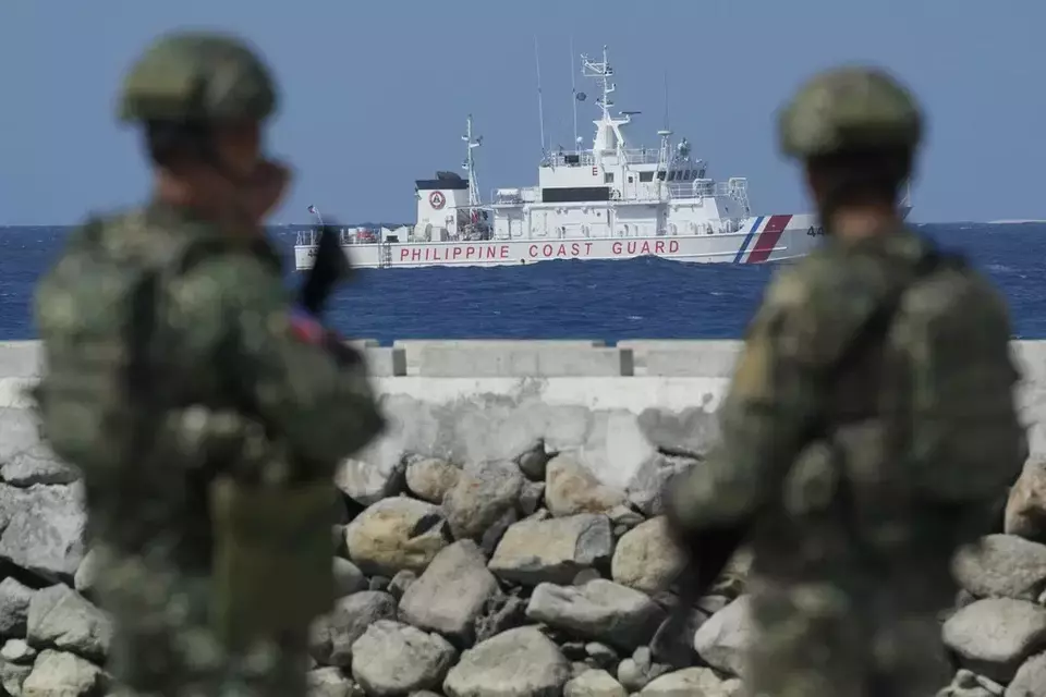 Philippine troops watches a Philippine coast guard ship as they secure an area at the Philippine-occupied Thitu island, locally called Pag-asa island, on Friday, Dec. 1, 2023 at the disputed South China Sea. (AP Photo/Aaron Favila)