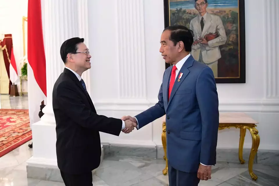 Hong Kong chief executive John Lee shakes hands with President Joko 
