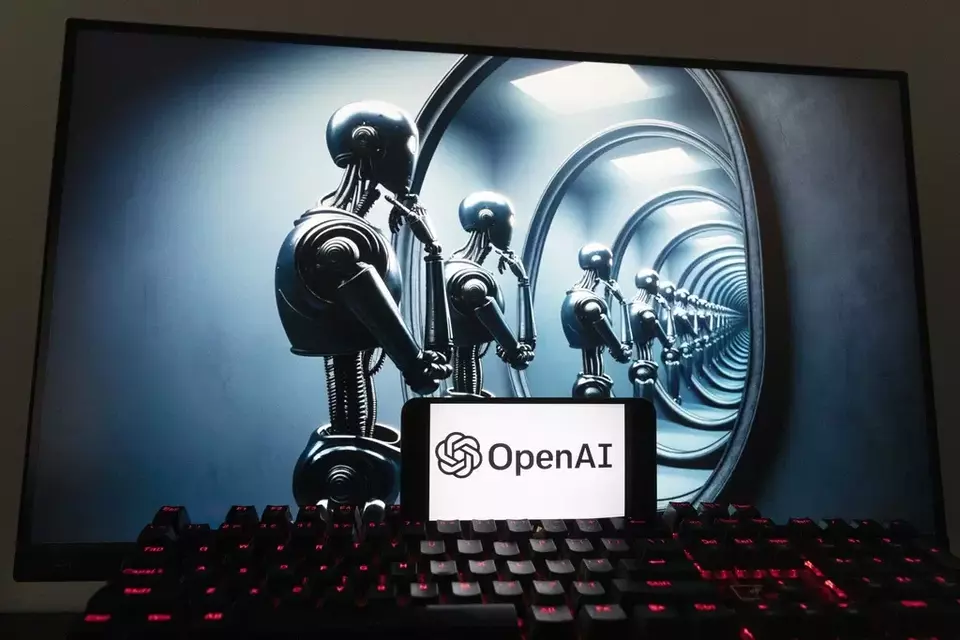 The OpenAI logo is seen displayed on a cell phone with an image on a computer screen generated by ChatGPT