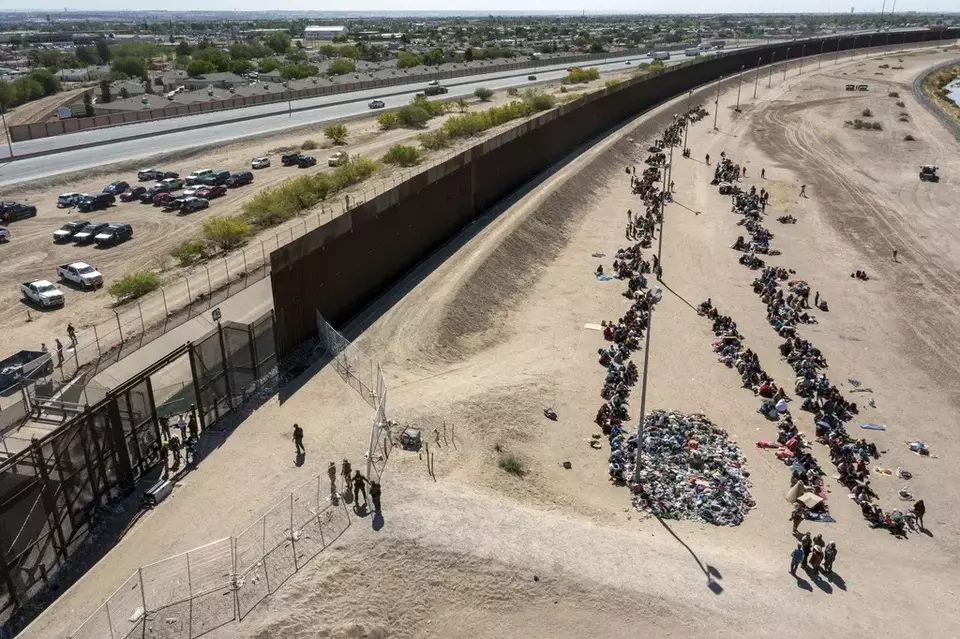 FILE - Migrants form lines outside the border fence waiting for transportation to a US Border Patrol facility in El Paso, Texas, May 10, 2023. (AP Photo/Andres Leighton, File)