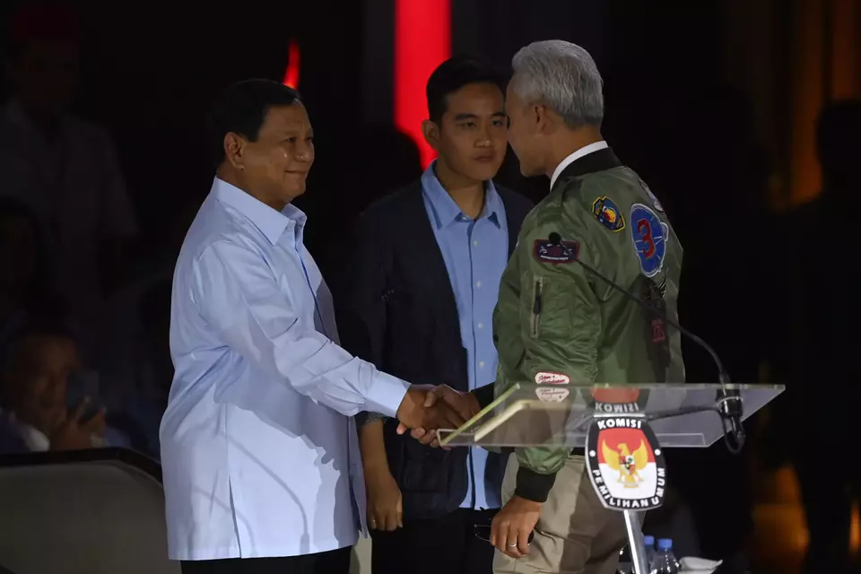 Presidential candidate Ganjar Pranowo, right, shakes hands with rival Prabowo Subianto before the presidential debate at the Istora Sports Stadium in Jakarta, Sunday, Jan. 7, 2024. (Antara Photo/Aditya Pradana Putra)