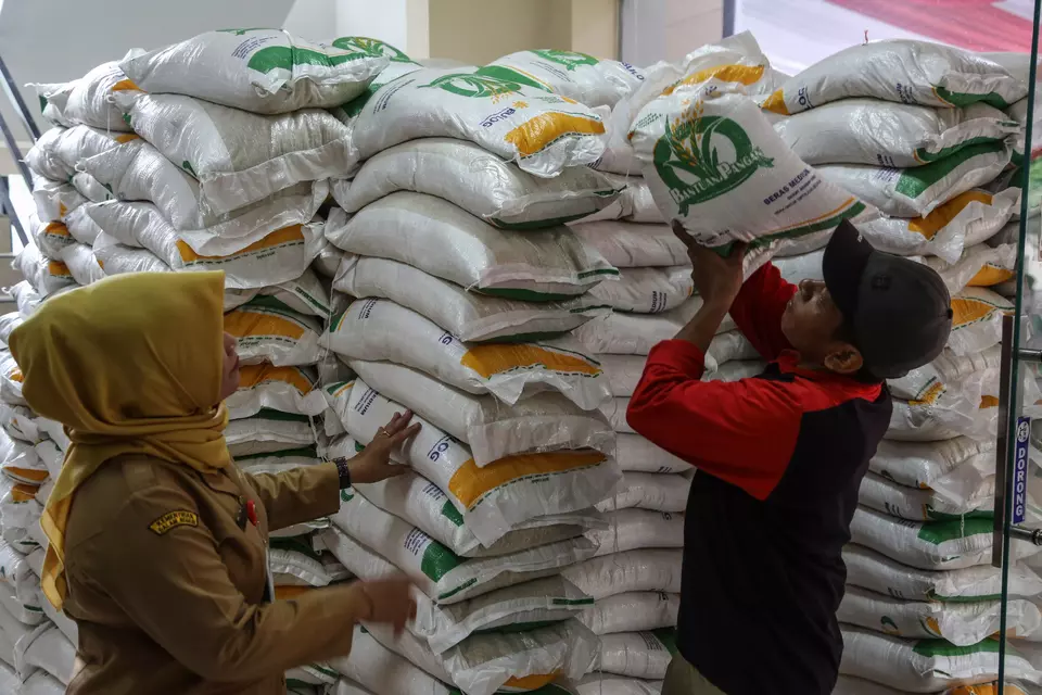 A worker piles up sacks of rice for distribution in Gemah subdistrict, Semarang, Central Java, Monday, Jan. 15, 2024. (Antara Photo/Makna Zaezar)
