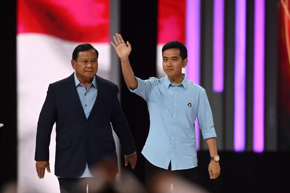 Presidential candidate Prabowo Subianto, left, and his running mate Gibran Rakabuming Raka greet supporters as they arrive at the Jakarta Convention Center (JCC) to attend a debate, Sunday, Jan. 21, 2024. (Antara Photo/M Risyal Hidayat)