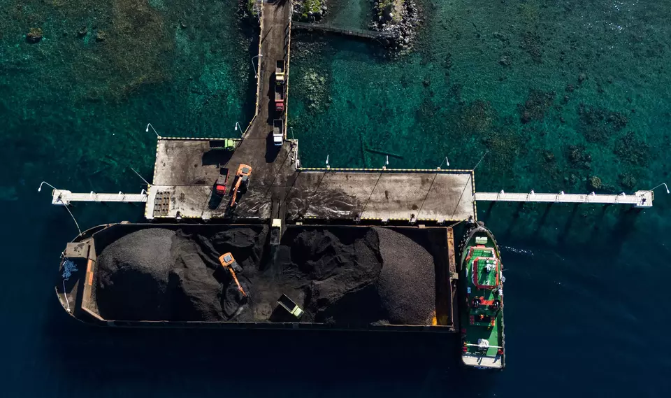 This aerial photo shows coal being unloaded from a barge at Tidore Islands Port in North Maluku, Thursday, Jan. 4, 2024. (Antara Photo/Andri Saputra)