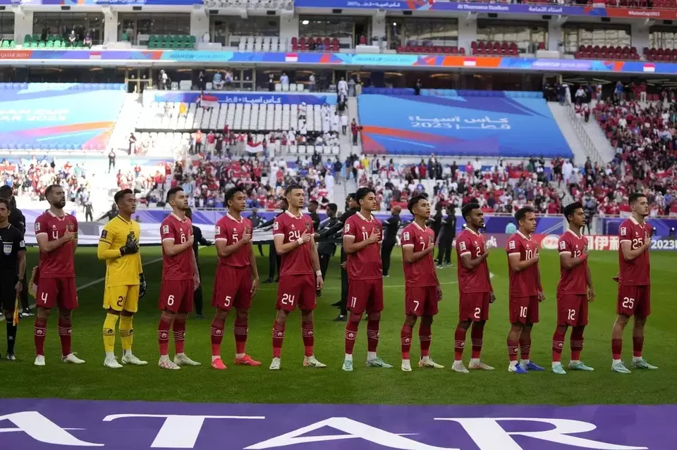 Indonesian players pay respect to their national anthem during the Asian Cup Group D soccer match between Japan and Indonesia at Al Thumama in Doha, Qatar, Wednesday, Jan. 24, 2024. (AP Photo/Thanassis Stavrakis)
