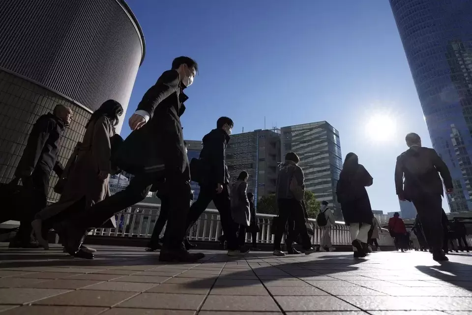 Commuters walk in a passageway during a rush hour at Shinagawa Station, Wednesday, Feb. 14, 2024, in Tokyo. (AP Photo/Eugene Hoshiko)