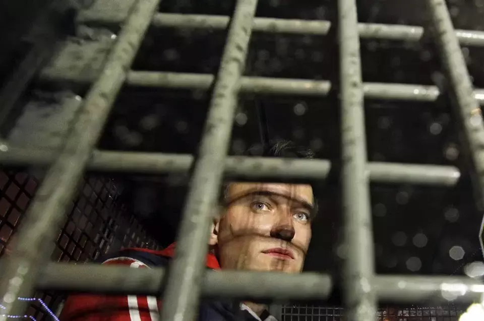 FILE - Alexei Navalny is seen behind the bars in the police van after he was detained during protests in Moscow, on May 8, 2012 a day after Putin's inauguration. (AP Photo/Sergey Ponomarev, File)