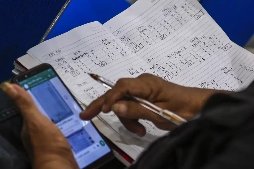 A political party representative uses his cellphone to match vote tallies with the hand-written documents in Tanah Abang, Jakarta, Monday, Feb. 19, 2024. (Antara Photo/Galih Pradipta)