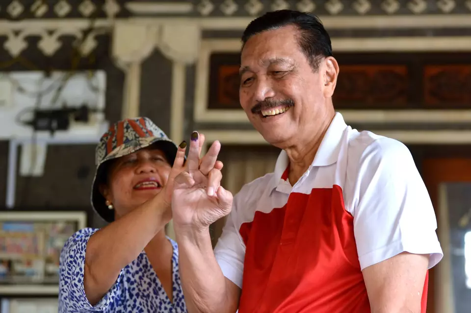 Chief Investment Minister Luhut Binsar Pandjaitan shows his ink-smeared finger after voting at a polling station in Bali on February 14, 2024. (Antara Photo/Fikri Yusuf)