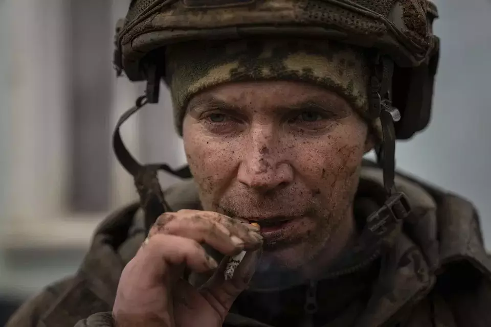A Ukrainian serviceman who recently returned from the trenches of Bakhmut smokes a cigarette in Chasiv Yar, Ukraine, Wednesday, March 8, 2023. (AP Photo/Evgeniy Maloletka)