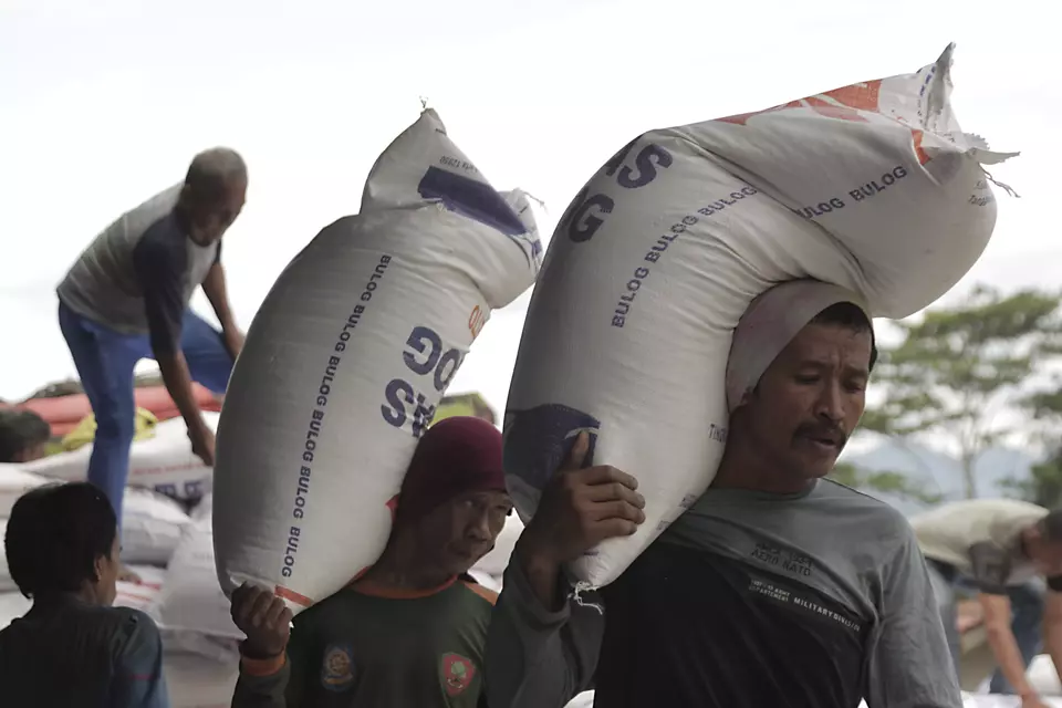 Workers carry bags of rice in Bulog Pasirhalang in Sukaraja on Feb. 26, 2024. (Antara Photo/Henry Purba)