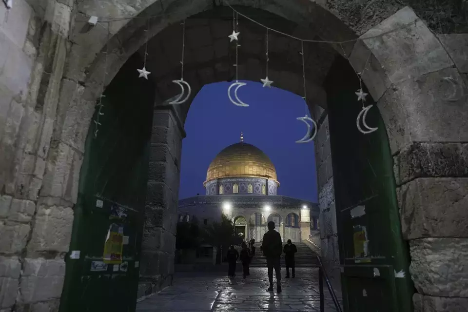 Muslims walk next to the Dome of Rock Mosque at the Al-Aqsa Mosque compound in Jerusalem