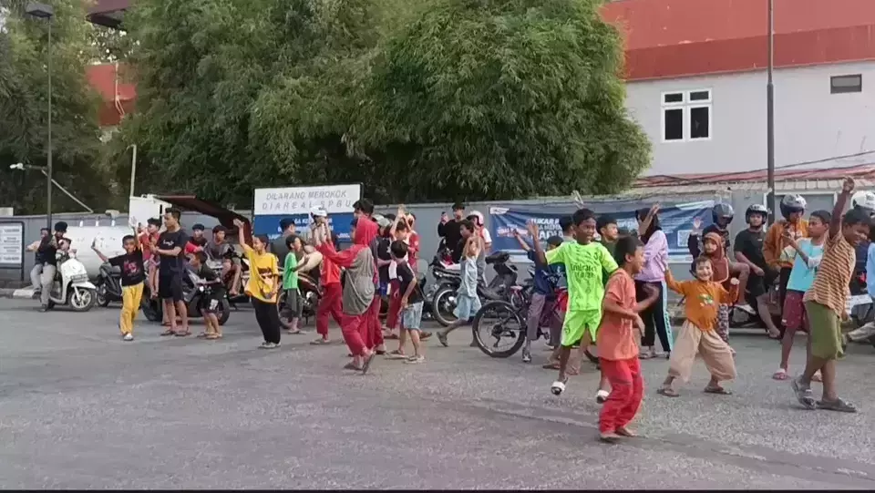 Dozens of children dance while listening to the sound of the telolet horn from a bus on Narogong Road, Cileungsi District, Bogor Regency, West Java. (Beritasatu.com/Desi Wahyuni)