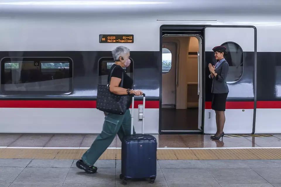 A passenger passes by the Whoosh Jakarta-Bandung high-speed railway at Jakarta's Halim Station on April 6, 2024. (Antara Photo/Galih Pradipta)