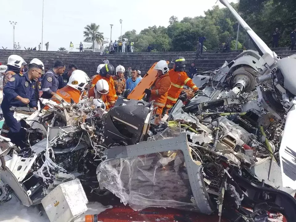 Fire & Rescue Department of Malaysia inspects the crash site of two helicopters in Lumur, Perak State, on Tuesday, April 23, 2024. (Malaysia