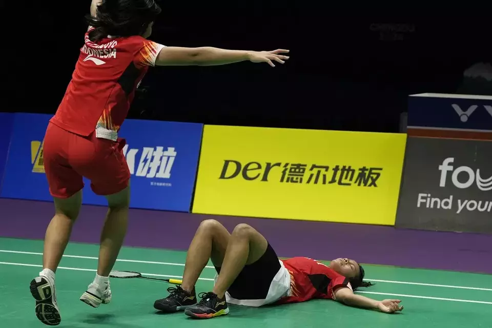 A teammate runs out to Komang Ayu Cahya Dewi as she lies on the court after defeating South Korean Kim Min Sun to lead Team Indonesia to a 3-2 win over Team South Korea in the semi-final of the Uber Cup Finals held in Chengdu, China, Saturday, May 4, 2024. (AP Photo/Ng Han Guan)