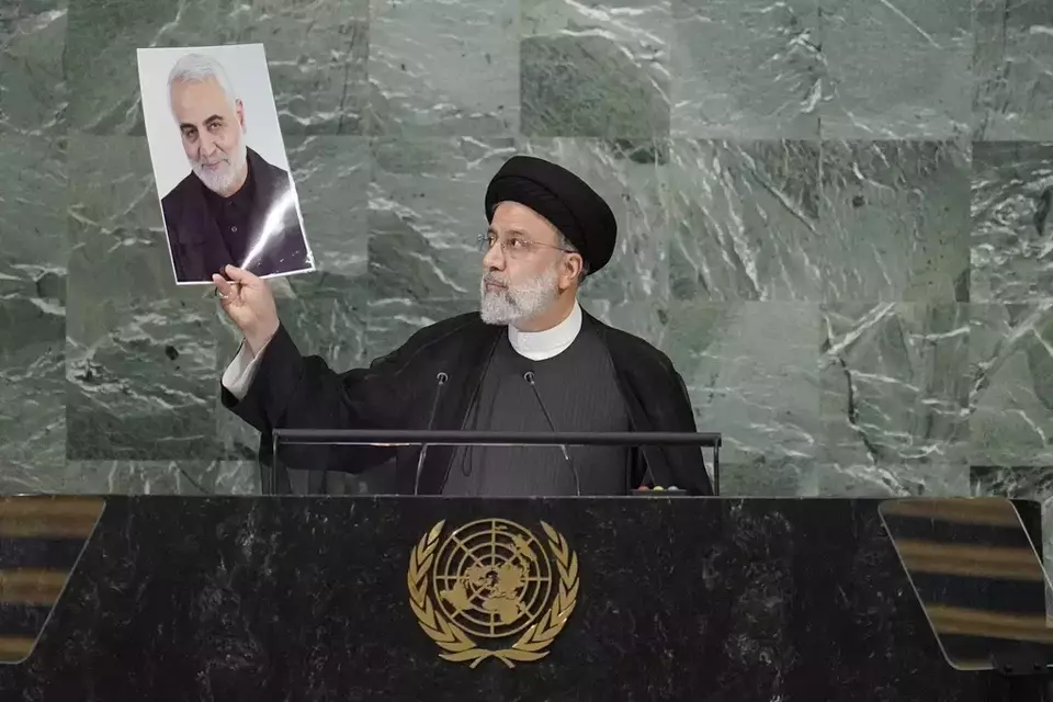 FILE - Iranian President Ebrahim Raisi holds up a photo of slain Iranian Gen. Qassem Soleimani, as he addresses the 77th session of the United Nations General Assembly, Sept. 21, 2022 at U.N. headquarters. (AP Photo/Mary Altaffer, File)