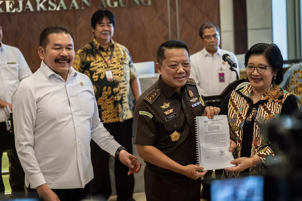 Attorney General Sanitiar Burhanuddin, left, his deputy for special crimes Febrie Adriansyah, center, receive documents detailing alleged state losses from a major graft scandal at the state-owned tin miner Timah from Agustina Arumsari, an official with the State Development Finance Controller (BPKP) at the Attorney General s Office in Jakarta, Wednesday, May 29, 2024. (Antara Photo/Bayu Pratama)