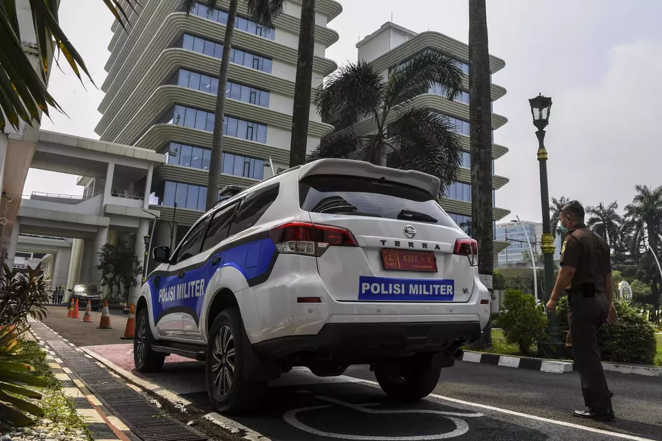 An employee walks near a Military Police vehicle at the Attorney General's Office in South Jakarta, Monday, May 27, 2024. Security was beefed up at the AGO building after the alleged spying on a top prosecutor a day earlier. (Antara Photo/Galih Pradipta)